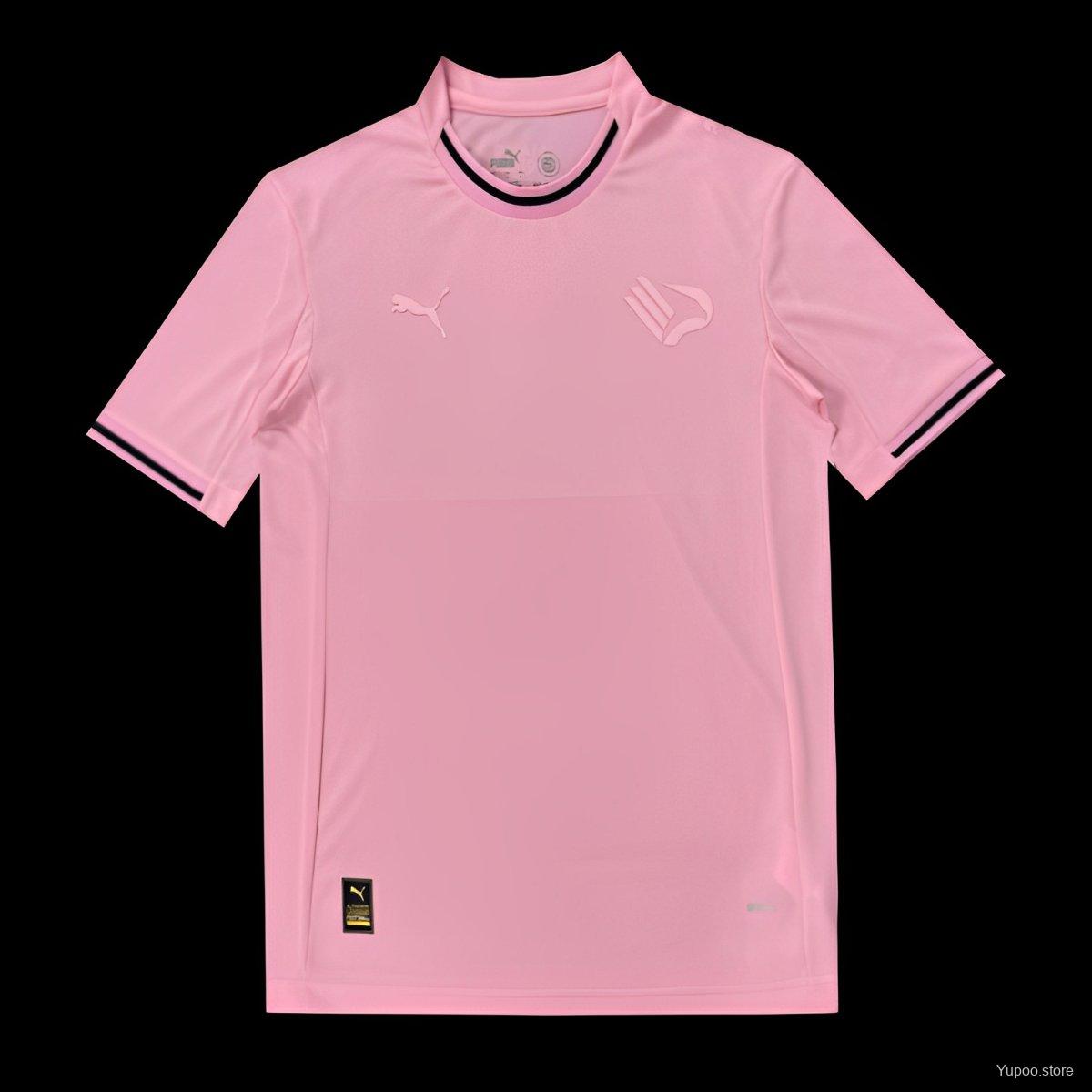 Maglietta rosa con logo Puma e stemma sul petto.