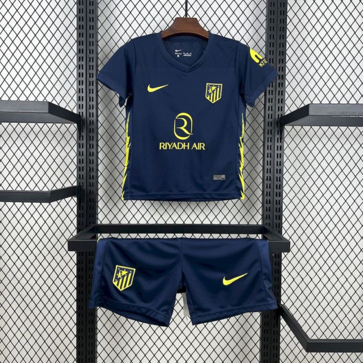 Completo da calcio blu con loghi gialli su griglia.